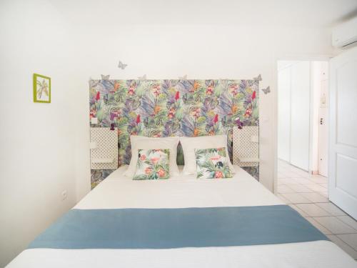 a bedroom with a bed with a floral wall at L'Oiseau Bleu - Superbe vue mer in Les Trois-Îlets