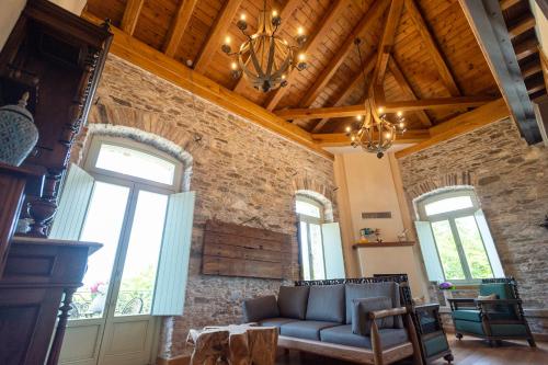 a living room with a couch and some windows at Nostos Country House in Tsagarada