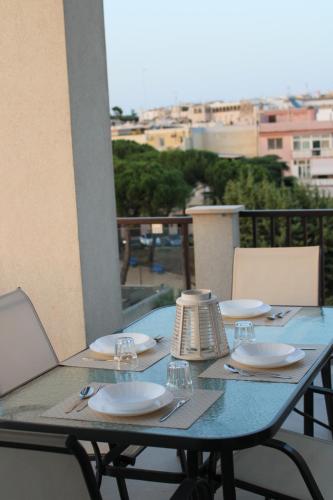 een tafel met borden en wijnglazen op een balkon bij Casa Terka in Conversano