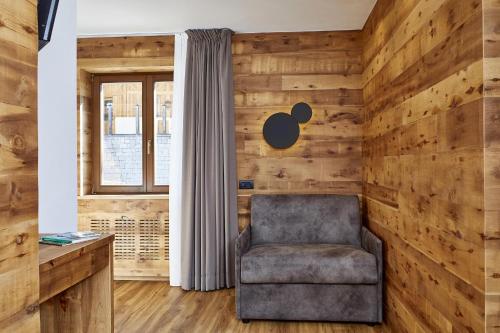 a chair in a room with wooden walls at Hotel Garni dello Sportivo in Madonna di Campiglio