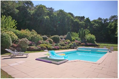 una piscina con un tobogán en un jardín en Le Pilori en Saint-Jacut-les-Pins