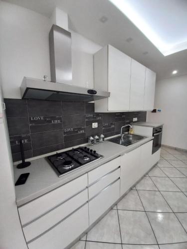 a kitchen with white cabinets and a stove top oven at BELLAVISTA House in San Salvo