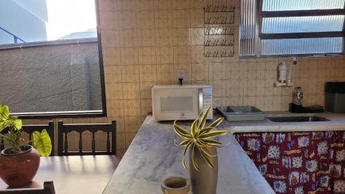 a kitchen with a counter with a microwave on it at Casa de Temporada - Solar Guest House in Saquarema