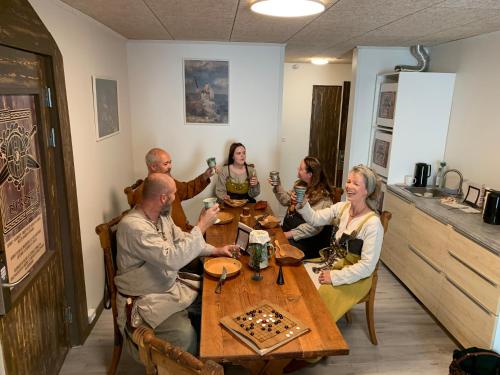 a group of people sitting around a wooden table at VikingBnB in Kirke Såby