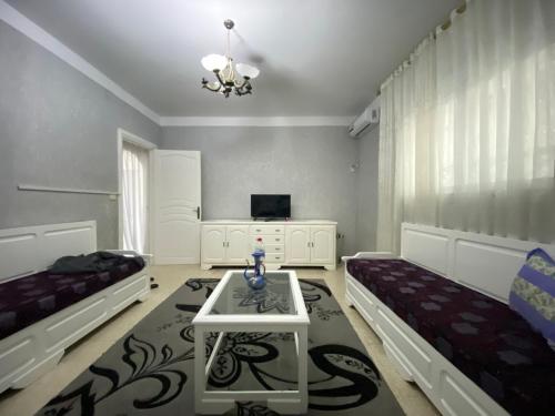 a living room with two beds and a table at Le bien être in Kelibia