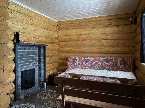 pokój z kominkiem w drewnianym domku w obiekcie Sadyba na Luzi w mieście Verkhne-Studënyy