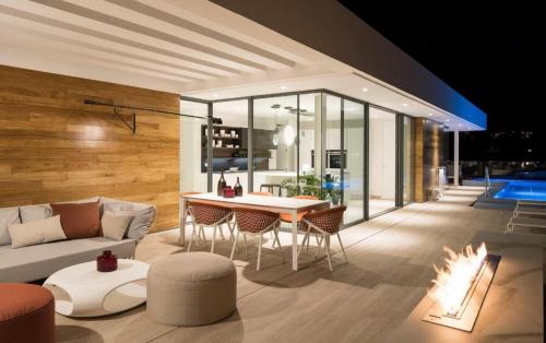 a living room with a couch and a table and a fireplace at Luxury Villa Rebeka - Heated Pool and Jacuzzi in Adeje