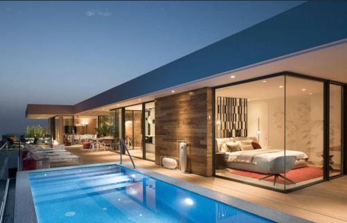 een slaapkamer en een zwembad in een huis bij Luxury Villa Rebeka - Heated Pool and Jacuzzi in Adeje