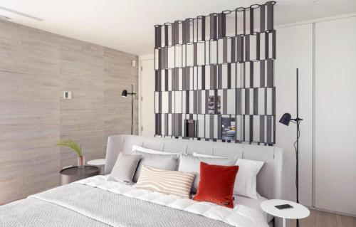 a bedroom with a large white bed with red pillows at Luxury Villa Rebeka - Heated Pool and Jacuzzi in Adeje