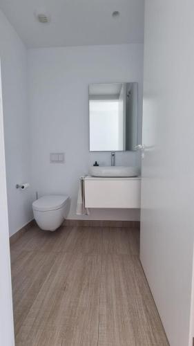 a bathroom with a sink and a toilet and a mirror at Luxury Villa Rebeka - Heated Pool and Jacuzzi in Adeje