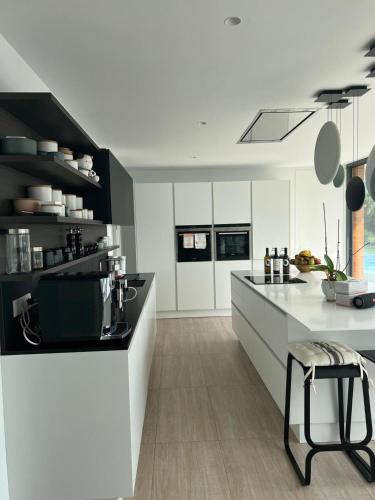 a kitchen with white cabinets and a black and white counter at Luxury Villa Rebeka - Heated Pool and Jacuzzi in Adeje