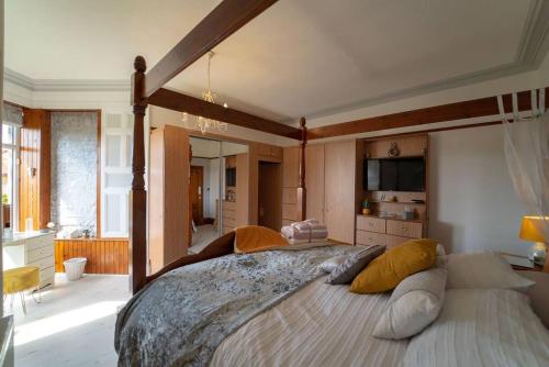 um quarto grande com uma cama grande com almofadas em Stunning Central Villa by Golf Course & Beach em Leven-Fife