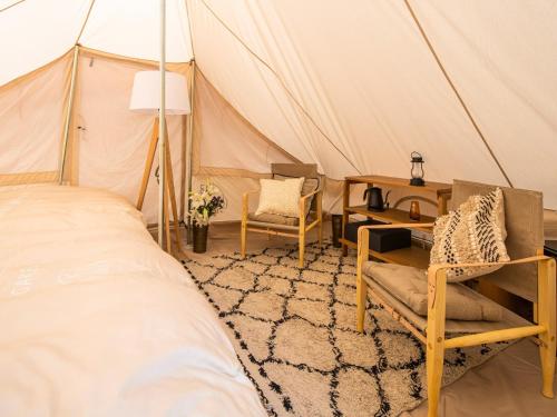 a bedroom with a bed and chairs in a tent at Nordisk Hygge Circles Ugakei - Vacation STAY 75327v in Komono