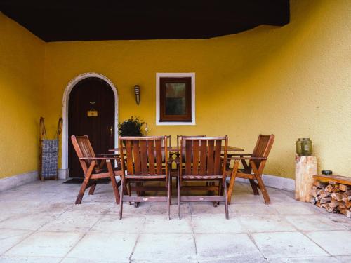 zwei Stühle und ein Tisch vor einer gelben Wand in der Unterkunft Haus Wasserbauer in Mühlbach am Hochkönig