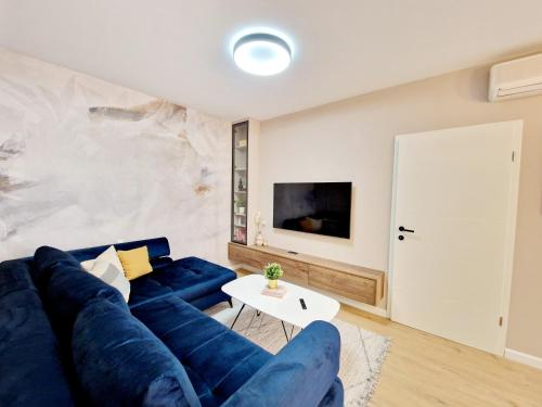 a living room with a blue couch and a table at Apartments Jasna in Rovinj