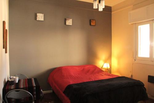 1 dormitorio con cama roja y ventana en La Morada - Dean Funes en Salta