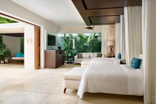 a bedroom with two beds and a living room at Chablé Yucatan in Chocholá