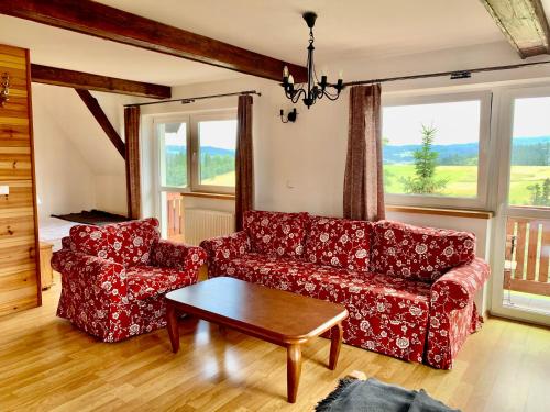uma sala de estar com um sofá vermelho e uma mesa em Willa Widokowa em Bukowina Tatrzańska