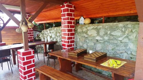 a restaurant with a wooden table and a stone wall at Orsova Gratca 164 in Orşova