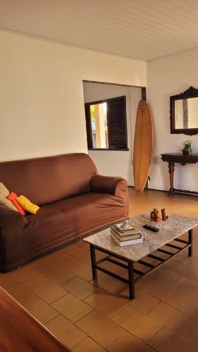 a living room with a brown couch and a coffee table at Casa de Temporada - Solar Guest House in Saquarema