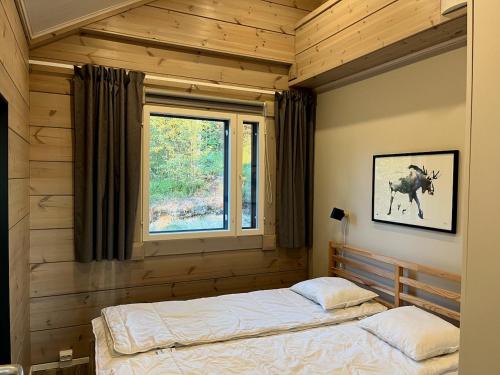 1 dormitorio con 1 cama en una habitación con ventana en Villa Breikki, Himos en Jämsä