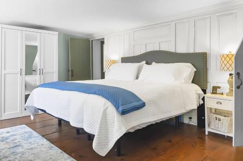 1 dormitorio con 1 cama grande con sábanas blancas y azules en Last House on the River, en Stonington