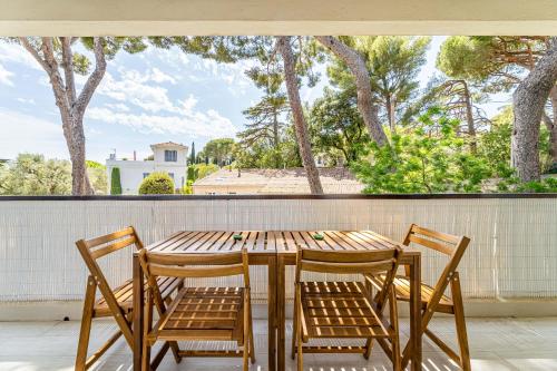 a wooden table and chairs on a balcony with a window at Bèn-vengu par Dodo-à-Cassis in Cassis