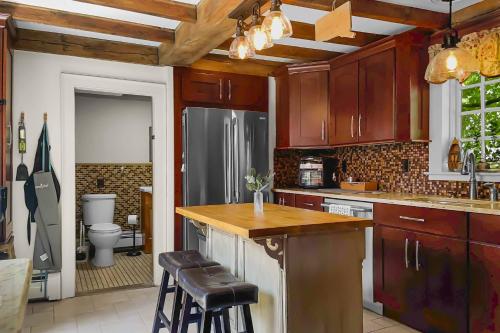 une cuisine avec des placards en bois et un comptoir avec des tabourets dans l'établissement Last House on the River, à Stonington