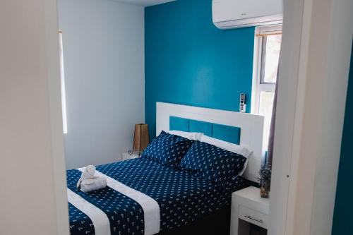Punta Esmeralda I في Altata: غرفة نوم زرقاء مع سرير بجدران زرقاء