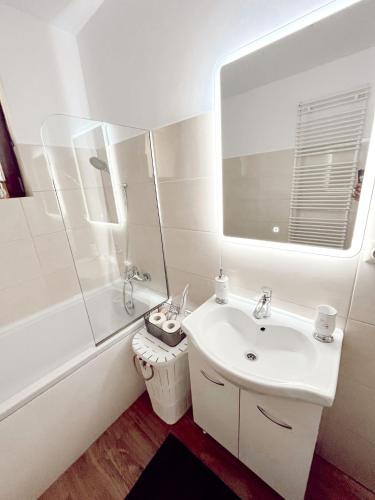 a white bathroom with a sink and a mirror at NS apartment 2 in Cluj-Napoca