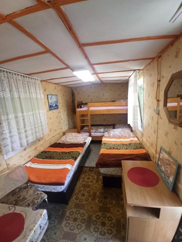 波皮耶洛伯的住宿－Na kemping!，一间设有三张床的房间,内设一张桌子