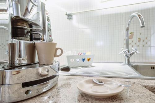 a kitchen counter with a coffee maker and a sink at Casa Vacanze Cisternino alcova nel centro storico in Cisternino
