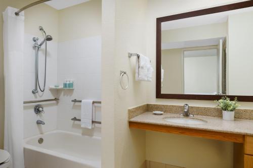 ein Badezimmer mit einer Badewanne, einem Waschbecken und einem Spiegel in der Unterkunft Residence Inn Orlando Altamonte Springs / Maitland in Orlando