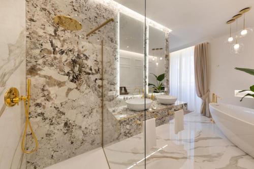 a bathroom with two sinks and a bath tub at Île Déluxe Apartment in Sorrento