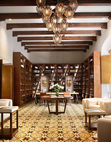 a library with a table and chairs and bookshelves at Chablé Yucatan in Chocholá