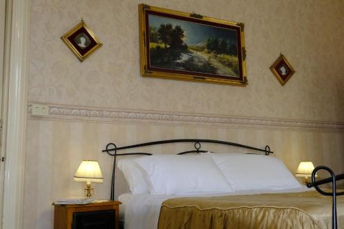 1 dormitorio con 1 cama y una pintura en la pared en Palazzo Vitrano - tourist apartment, en Catania