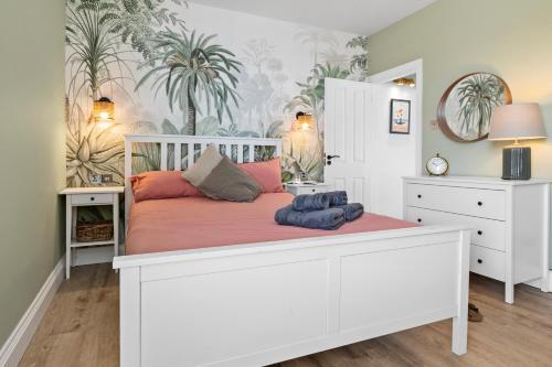 a bedroom with a white bed with pink pillows at Cosy & Bright Home with Backyard in Southsea Portsmouth in Portsmouth