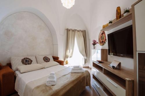 1 dormitorio con 1 cama y TV de pantalla plana en Casa Vacanze Cisternino alcova nel centro storico, en Cisternino