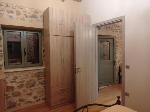 a bedroom with wooden cabinets and a door to a room at Villa ALONIA in Kalamata