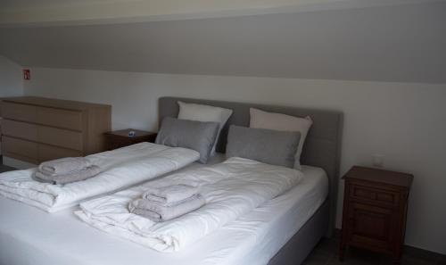 a large white bed with two towels on it at Vakantiewoning Den Appel in Dendermonde