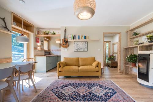 ein Wohnzimmer mit einem gelben Sofa und einem Tisch in der Unterkunft LA CASA NEL BOSCO 