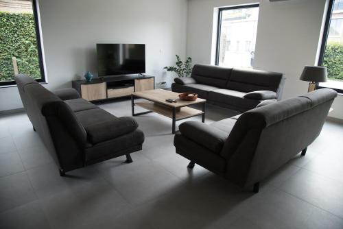 a living room with two couches and a tv at Vakantiewoning Den Appel in Dendermonde