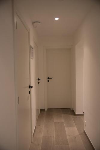 an empty hallway with two doors and a tile floor at Vakantiewoning Den Appel in Dendermonde