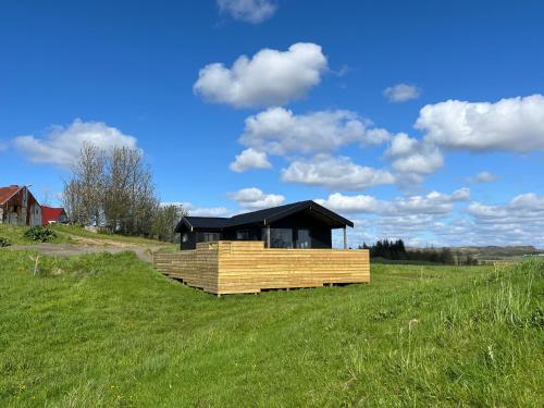 una casa en una colina con un campo verde en Iceland Inn Cabin, en Selfoss