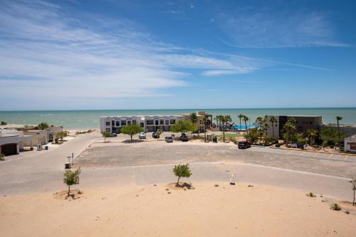 ein großer Parkplatz mit einem Gebäude und dem Meer in der Unterkunft Laguna Shores Resort in Puerto Peñasco