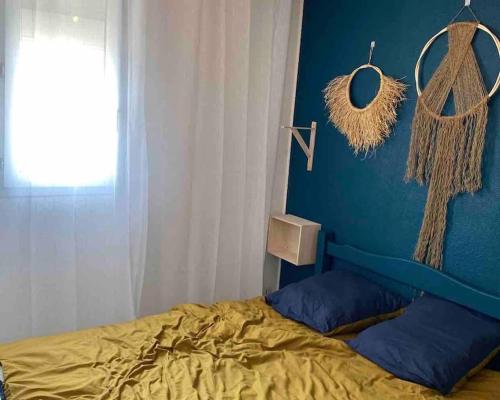 a bedroom with a bed and a blue wall at Logement entier 6 pers à 500m de la plage in Sète