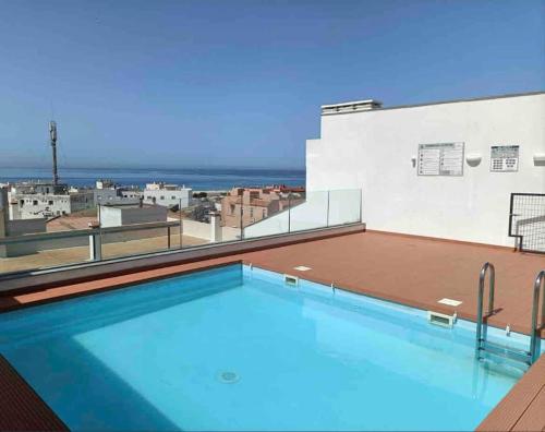 une piscine sur le toit d'un bâtiment dans l'établissement Ático Superior con Terraza Vistas Jacuzzi y Wifi - Poniente Penthouse, à Tarifa