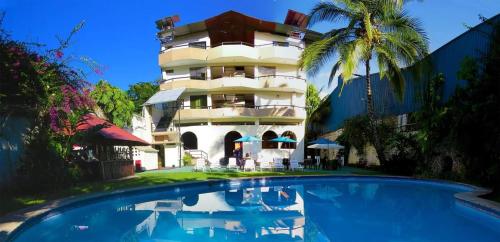 a hotel with a swimming pool in front of a building at Chanchamayo Inn Hotel in La Merced