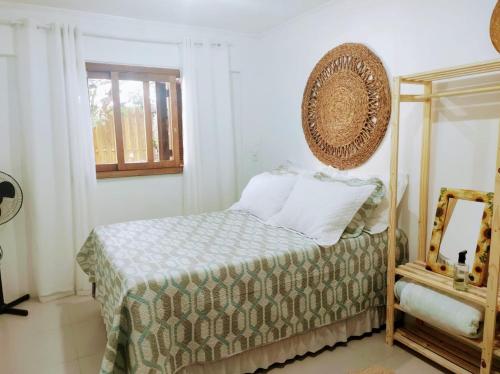 a bedroom with a bed and a mirror at Morada Héstia in Imbé