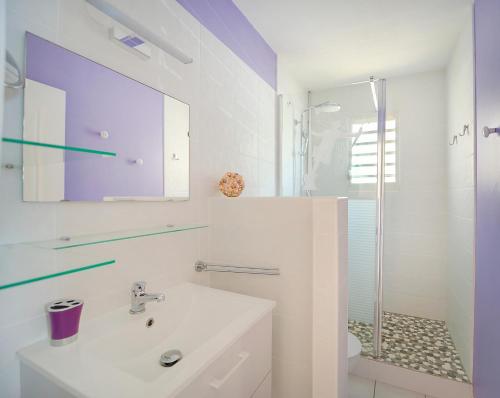 a white bathroom with a sink and a shower at L'Oiseau Bleu - Superbe vue mer in Les Trois-Îlets